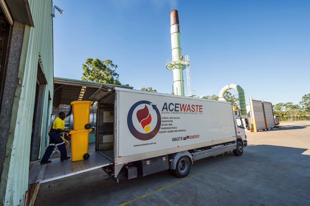 Man unloading clinical waste bins into waste collection truck